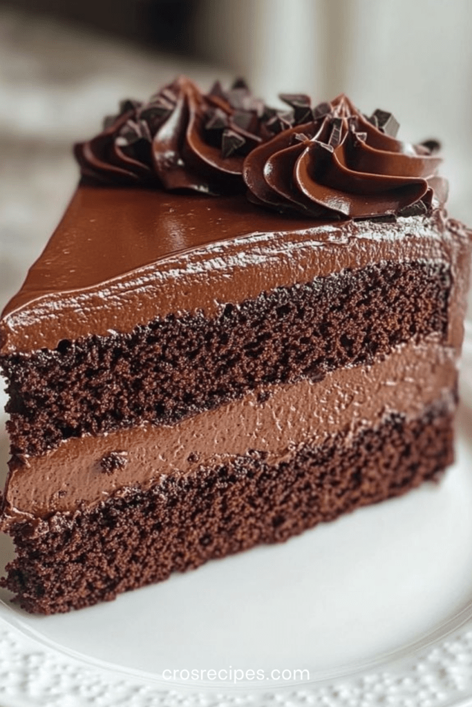 Gâteau au chocolat coupé en deux couches, garni d’une mousse aérienne, recouvert d’une ganache brillante et lisse, avec une texture fondante et intense.
