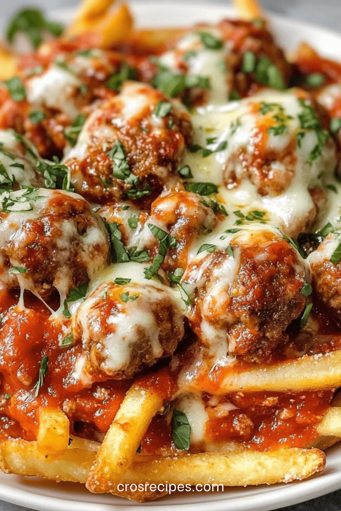 Frites de boulettes panées dorées et croustillantes, garnies de fromage fondant, servies chaudes avec sauce marinara dans un plat rustique.