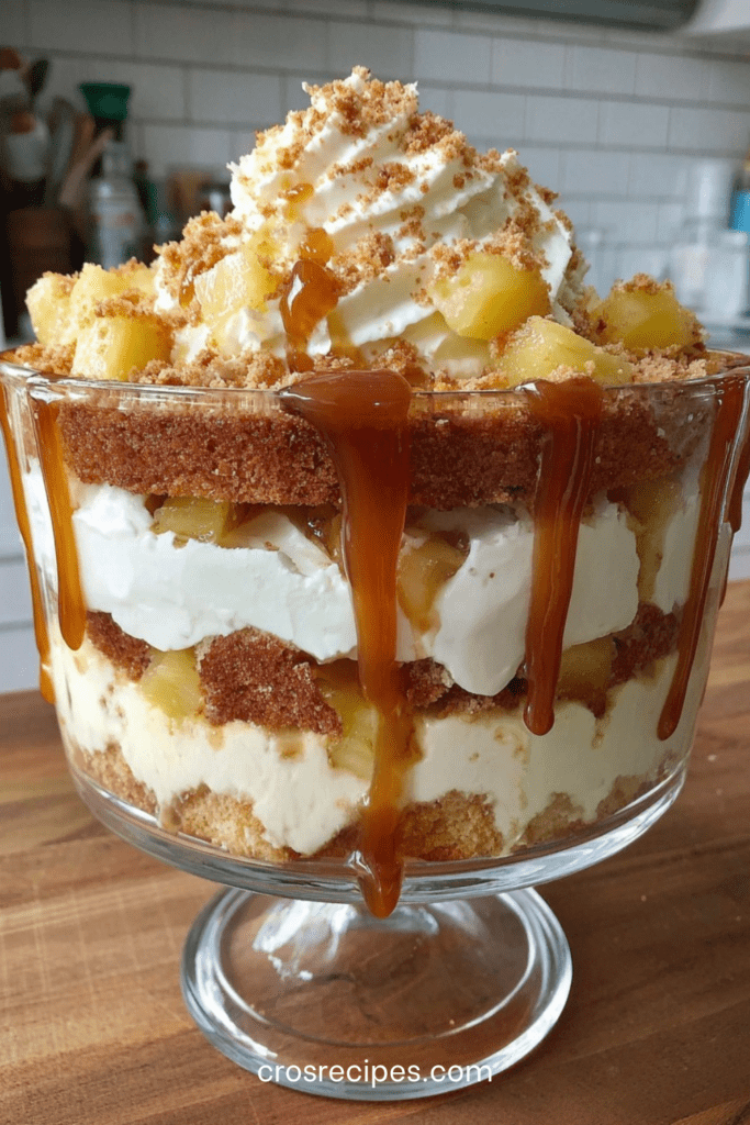 Verrines pommes composées de couches de pommes fondantes, crème légère au fromage frais et caramel coulant, décorées de biscuits émiettés et morceaux de pommes.