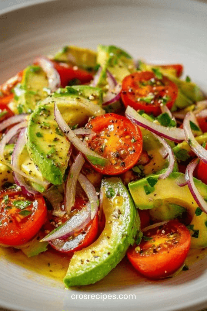 Salade fraîche avec avocat en cubes, tomates cerises coupées et fines lamelles d’oignon rouge, assaisonnée d’huile d’olive et citron.
