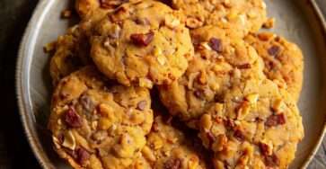 Cookies salés au parmesan chorizo et noix, dorés et croustillants, servis sur une planche avec morceaux visibles de chorizo et éclats de noix