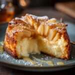 Gâteau fondant pommes et mascarpone, tranché avec une texture moelleuse et des lamelles de pommes visibles, servi sur une assiette dessert