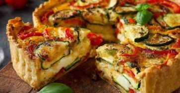 Tarte aux légumes courgettes et poivrons dorée au four, avec une garniture colorée et une pâte croustillante, servie en parts