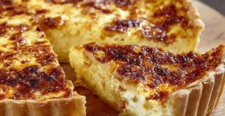 Quiche lorraine traditionnelle dorée, avec pâte croustillante et garniture crémeuse aux œufs et lardons, servie en parts.