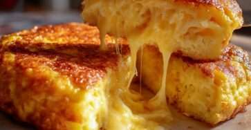 Omelette épaisse dorée au fromage fondant, cœur filant, garnie de ciboulette fraîche, servie chaude dans une poêle façon bistrot.