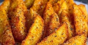 Potatoes wedges dorées et croustillantes au parmesan, avec peau, disposées sur une plaque, texture fondante à l’intérieur.