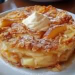 Croustade aux pommes dorée au four, avec une couche croustillante sablée et des pommes fondantes légèrement caramélisées, servie tiède dans un plat rustique.