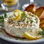 Crème de thon apéritive servie dans un bol, texture lisse et crémeuse, accompagnée de pain grillé et d’herbes fraîches finement ciselées.