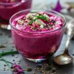 Verrines de mousse de betterave et feta, texture lisse et rose vif, garnies d’herbes fraîches et de graines croquantes dans des verres élégants.