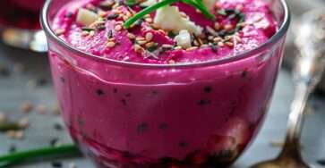 Verrines de mousse de betterave et feta, texture lisse et rose vif, garnies d’herbes fraîches et de graines croquantes dans des verres élégants.