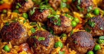 Assiette de riz coloré aux petits pois et poivrons, surmonté de boulettes de viande dorées, garni d’herbes fraîches, présentation chaleureuse.