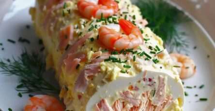 Bûche salée au saumon fumé et crevettes, garnie d’une mousse légère au fromage frais, décorée de ciboulette et servie bien fraîche.