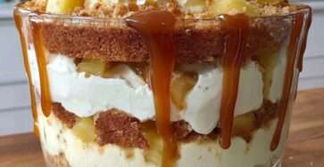 Verrines pommes composées de couches de pommes fondantes, crème légère au fromage frais et caramel coulant, décorées de biscuits émiettés et morceaux de pommes.