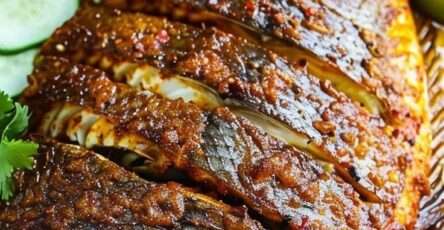 Poisson entier grillé doré et croustillant, mariné aux épices, servi avec citron vert, concombre et sauce pimentée aux herbes.