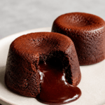 Fondant au chocolat cœur coulant servi tiède, avec un intérieur chocolat fondu, une texture moelleuse et une surface légèrement craquelée.