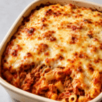 Gratin de pâtes au thon, sauce tomate et fromage râpé, bien doré au four dans un plat familial, avec une texture fondante et gratinée.