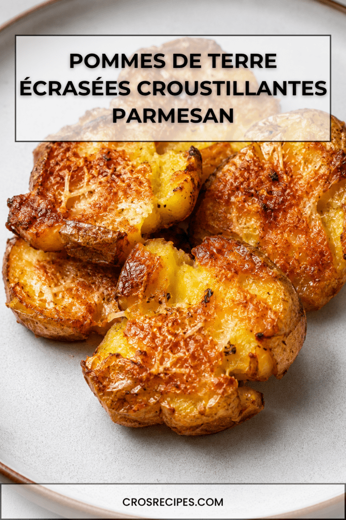 Pommes de terre écrasées croustillantes au parmesan, bien dorées au four, avec une surface croustillante, des herbes et du parmesan gratiné.