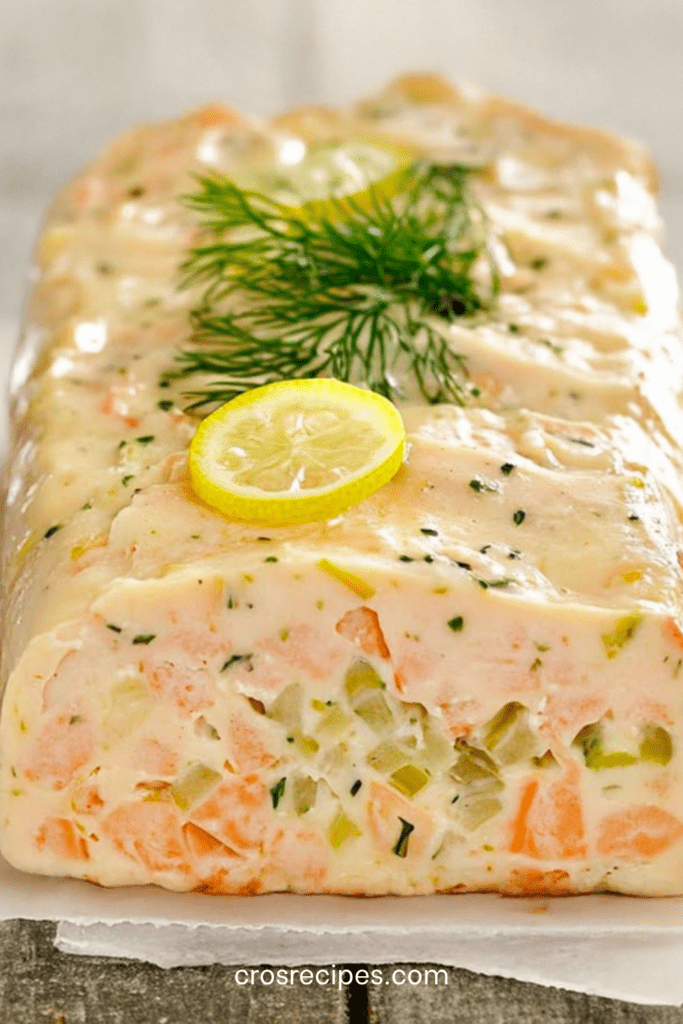 Terrine de poisson maison aux légumes, poisson blanc et saumon, coupée en tranches fraîches, servie avec sauce citronnée et herbes fraîches.