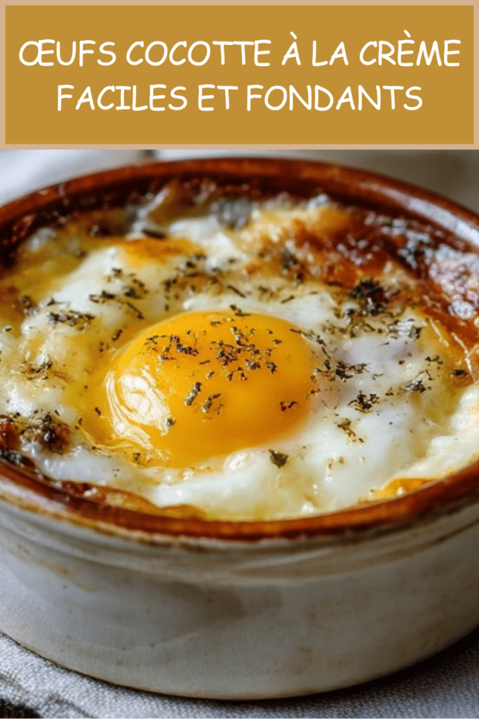 Œufs cocotte à la crème fraîche servis dans des ramequins, avec fromage râpé fondu, poivre noir et jaune d’œuf coulant.