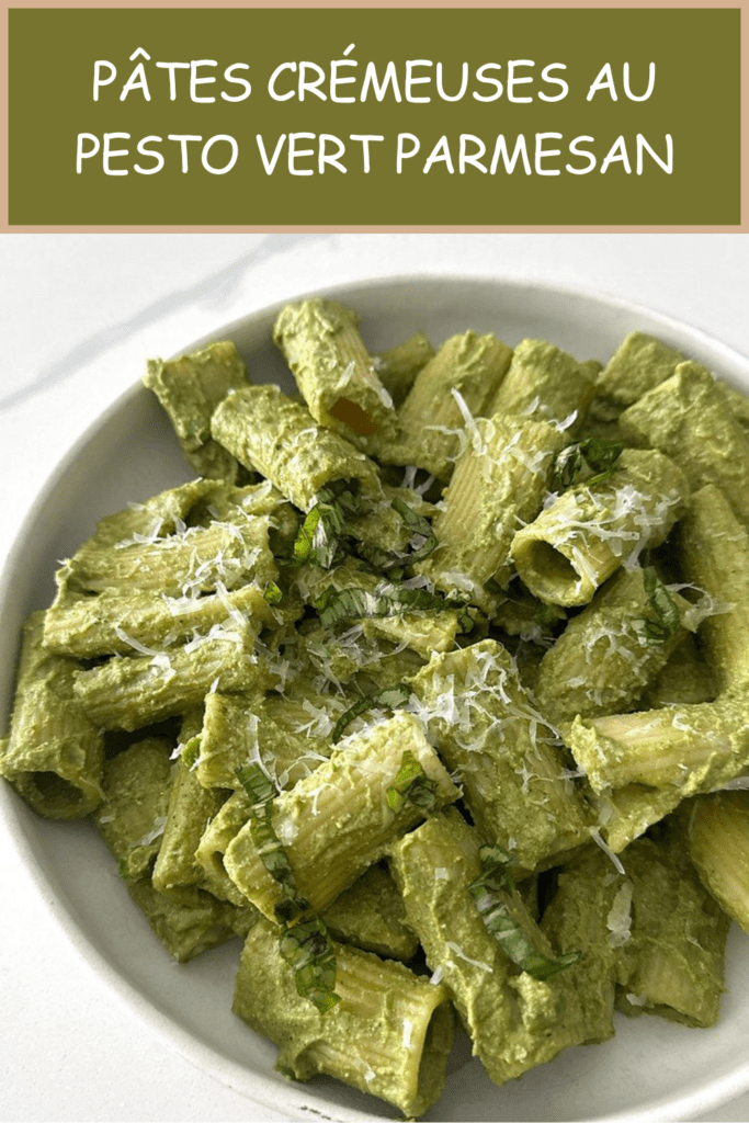 Pâtes crémeuses au pesto vert servies dans une assiette creuse avec parmesan râpé, basilic frais et sauce verte onctueuse.