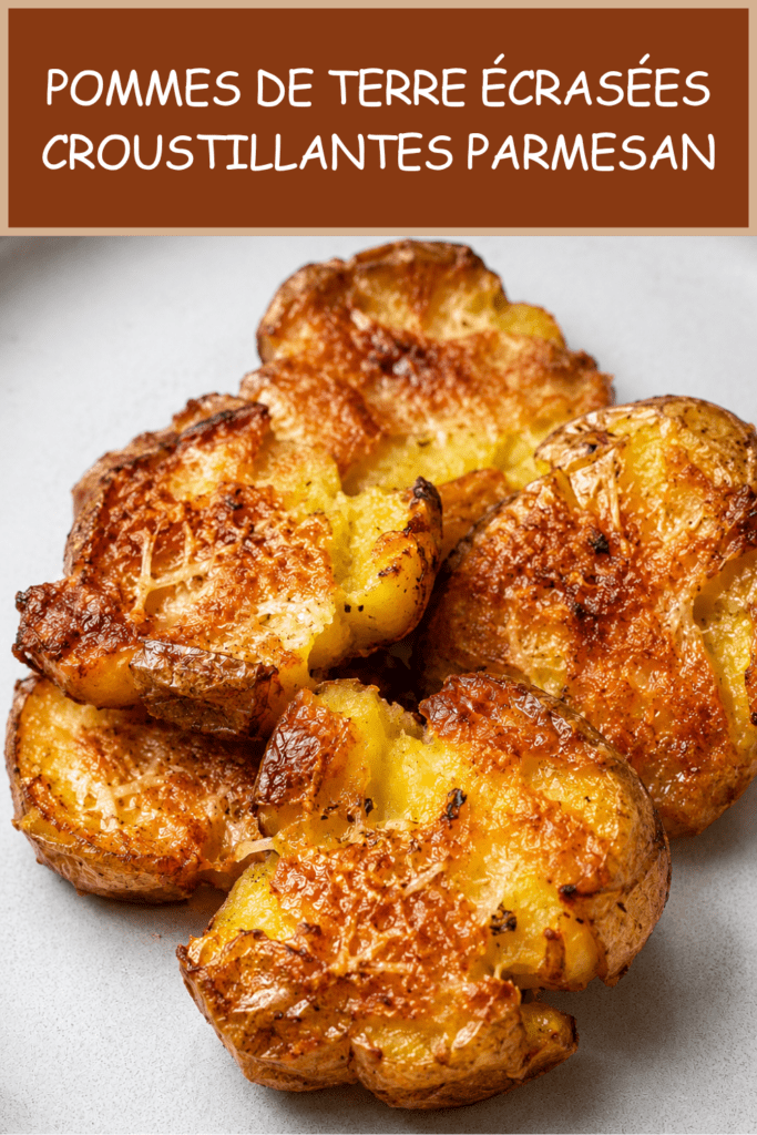 Pommes de terre écrasées croustillantes au parmesan, bien dorées au four, avec une surface croustillante, des herbes et du parmesan gratiné.