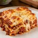 Lasagnes maison fondantes et gratinées servies en part généreuse, avec sauce tomate à la viande, béchamel crémeuse et fromage doré.