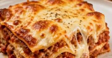 Lasagnes maison fondantes et gratinées servies en part généreuse, avec sauce tomate à la viande, béchamel crémeuse et fromage doré.