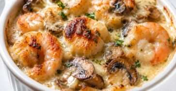 Cassolettes gratinées de noix de Saint-Jacques, crevettes et champignons, nappées de crème, fromage râpé, chapelure et persil frais.