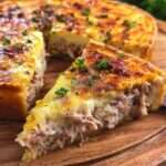 Quiche au thon crémeuse et dorée, garnie de thon émietté, fromage râpé, persil frais et pâte brisée croustillante.