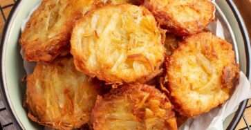 Beignets d’oignons croustillants dorés à la poêle, préparés avec une pâte légère à la farine, œuf, eau et levure, servis chauds.