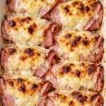 Roulés de jambon gratinés avec sauce crémeuse et fromage fondu doré servis dans un plat chaud familial