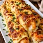 Cannelloni gratinés aux crevettes avec sauce crémeuse à l’ail et fromage fondu doré servis dans un plat chaud