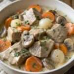 Blanquette de veau crémeuse avec carottes et champignons servie dans une assiette chaude accompagnée de riz
