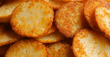 Chips sucrées de pomme de terre dorées et croustillantes, saupoudrées de cannelle et de sucre glace, servies dans un bol rustique.