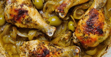 Pilons de poulet rôti bien dorés servis avec olives vertes, oignons confits, sauce parfumée aux herbes et jus de cuisson dans une cocotte.