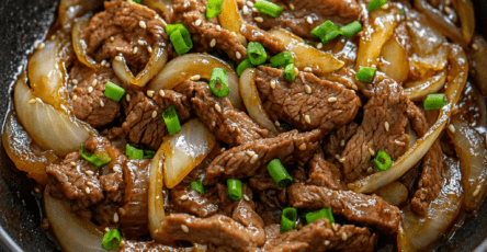 Sauté de bœuf et d’oignons à la chinoise servi avec une sauce brillante, des lamelles de bœuf tendres, des oignons fondants et du riz blanc.