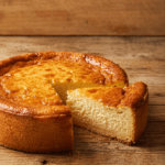 Gâteau au yaourt moelleux et doré, servi en parts sur une assiette, avec une texture légère et une surface légèrement croustillante.
