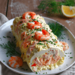 Bûche salée de la mer au saumon fumé et crevettes, servie bien fraîche avec ciboulette, citron et décoration festive.