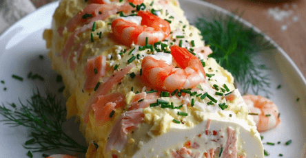 Bûche salée de la mer au saumon fumé et crevettes, servie bien fraîche avec ciboulette, citron et décoration festive.