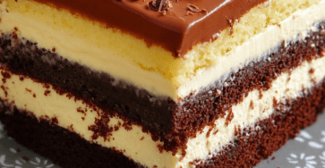 Gâteau chocolat double crème en plusieurs couches, garni de crème vanille, nappé de ganache chocolat et décoré de copeaux de chocolat noir et blanc.