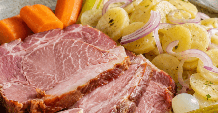 Tranches épaisses de Schiffele alsacien, une palette de porc fumée tendre, servies avec une salade de pommes de terre, des cornichons et des petits oignons au vinaigre.