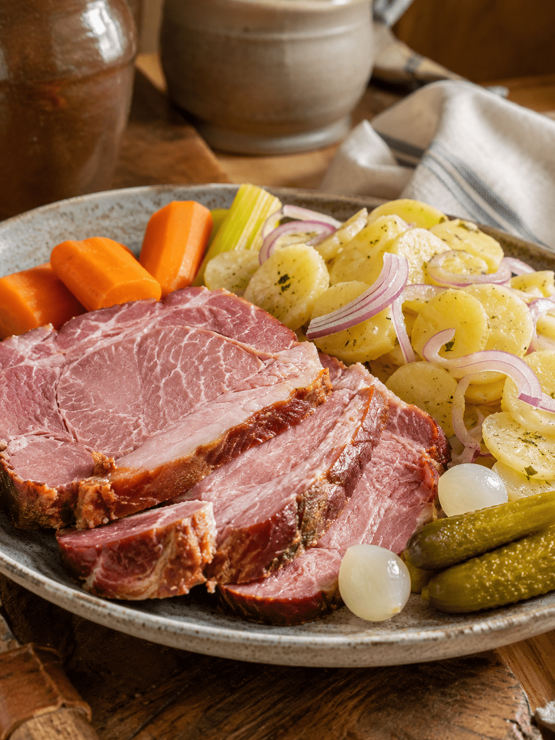 Tranches épaisses de Schiffele alsacien, une palette de porc fumée tendre, servies avec une salade de pommes de terre, des cornichons et des petits oignons au vinaigre.