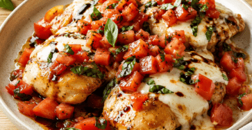 Poulet bruschetta facile aux tomates et mozzarella présenté dans une vaisselle claire, avec les ingrédients principaux visibles et une lumière naturelle chaude.