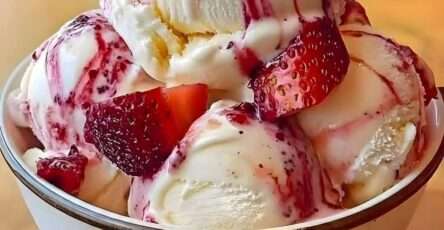 Boules de glace vanille crémeuse servies avec un coulis de fraises brillant, des morceaux de fraises fraîches et un effet marbré gourmand.