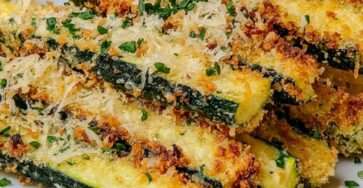 Frites de courgettes dorées et croustillantes au parmesan, servies avec une sauce crémeuse au yaourt, citron et herbes fraîches.