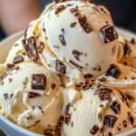 Boules de glace stracciatella maison servies dans un bol, avec une crème vanillée onctueuse et de généreux éclats de chocolat croquant.