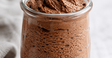 Mousse au chocolat sans œufs servie dans de petites verrines, avec une texture légère et aérienne obtenue grâce à l’aquafaba, décorée de copeaux de chocolat noir.