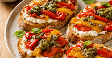 Des tartines croustillantes garnies de chèvre frais, de poivrons fondants et d’un pesto parfumé