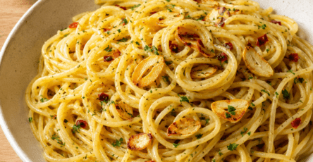 Assiette de spaghetti aglio e olio avec ail doré, persil frais, piment rouge et chapelure croustillante.