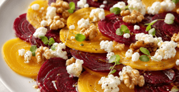 Carpaccio de betteraves rouges et jaunes coupées en fines rondelles, garni de chèvre frais émietté, de noix concassées, de jeunes pousses et d’huile de noix.
